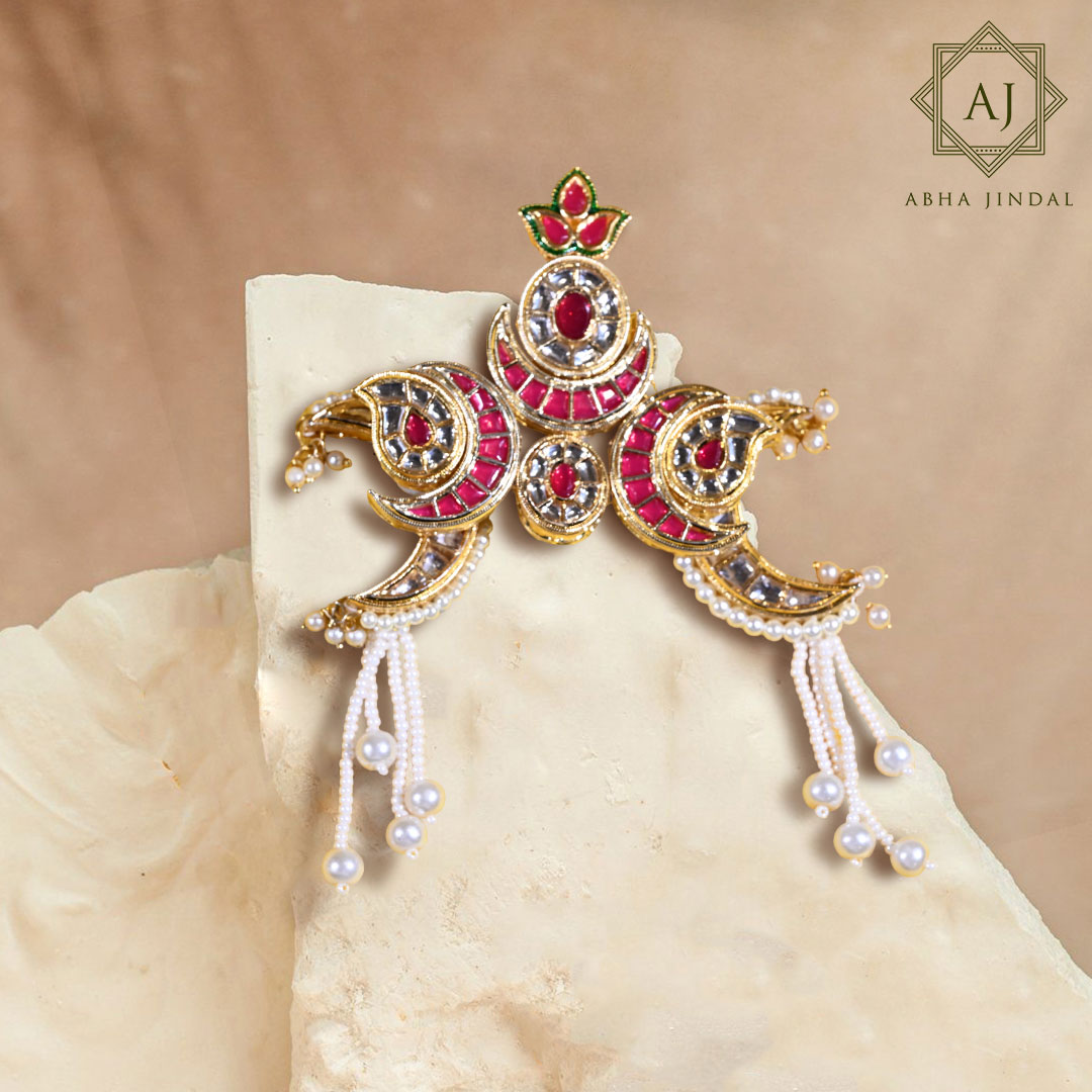 Ruby-toned deity shringar ornament with pearl drops.