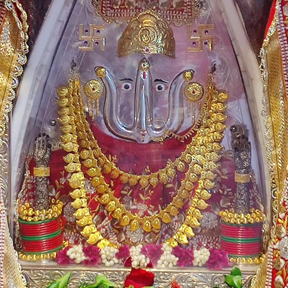 Rani Sati Dadi jewellery and red floral adornment at Calcutta Gol Mandir.