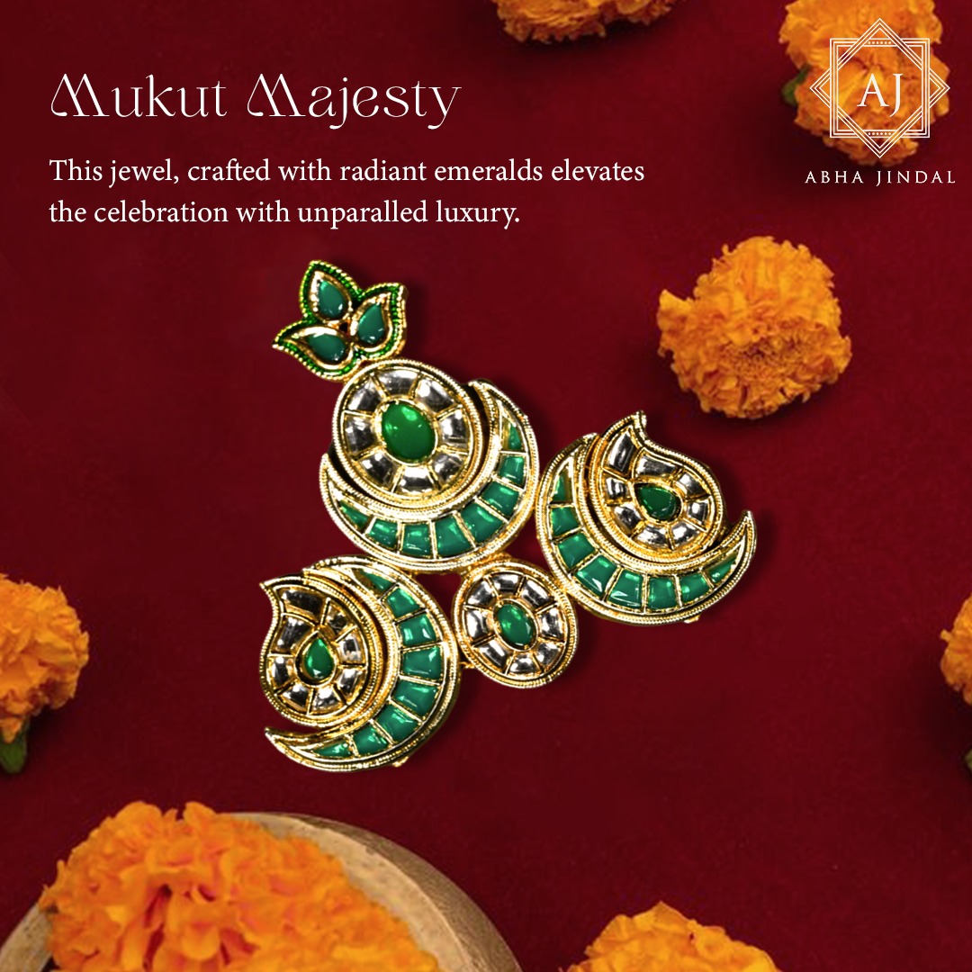 Gold-tone Emerald Mukut sections with green crescent motifs, a central green accent, clear accents and a leaf-like crest against red fabric
