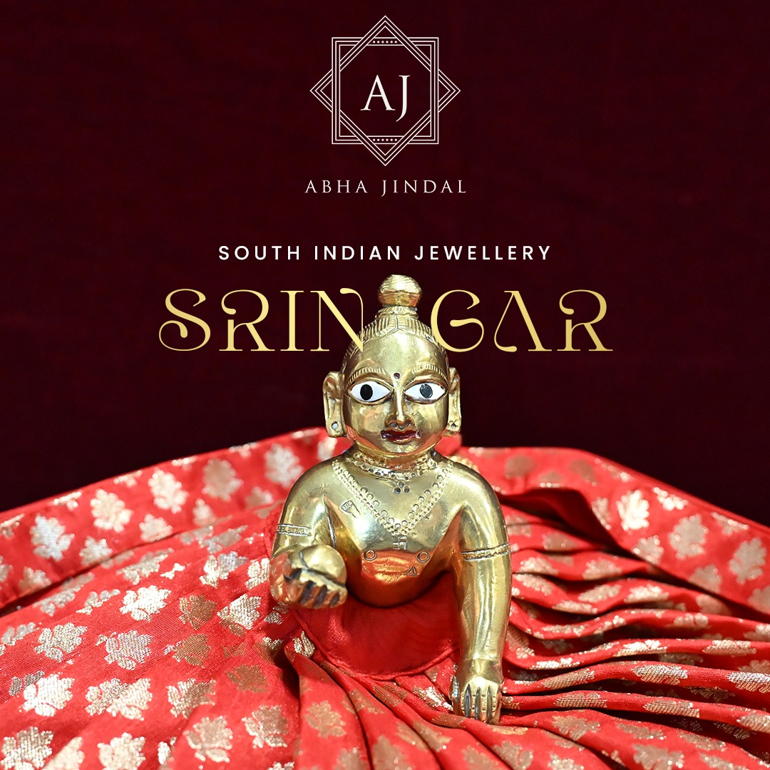 Laddu Gopal wearing the red patterned poshak before the additional mukut and jewellery