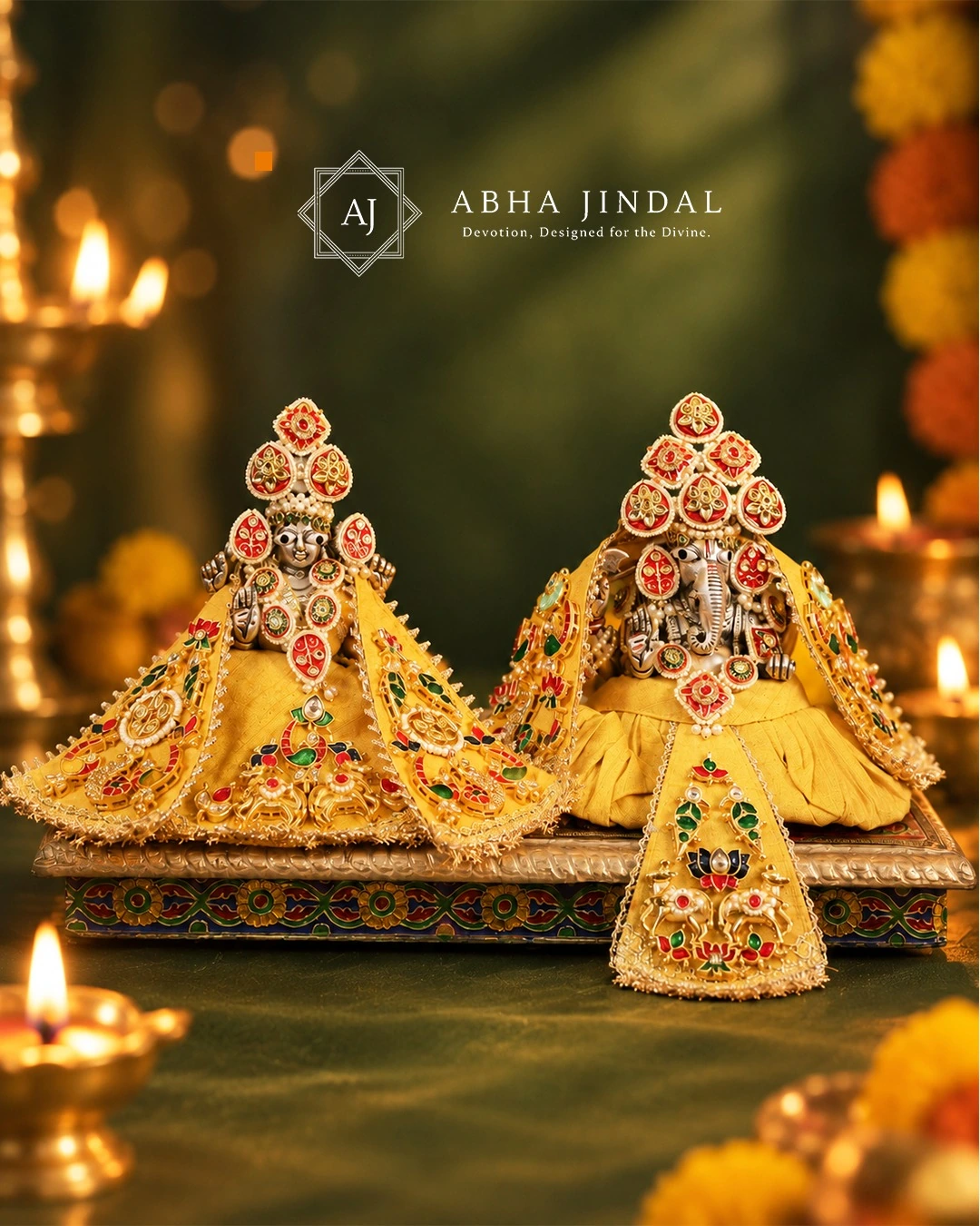 Lakshmi Ji and Ganesh Ji together in coordinated yellow Rajwada poshaks with colourful devotional motifs and red head adornments.