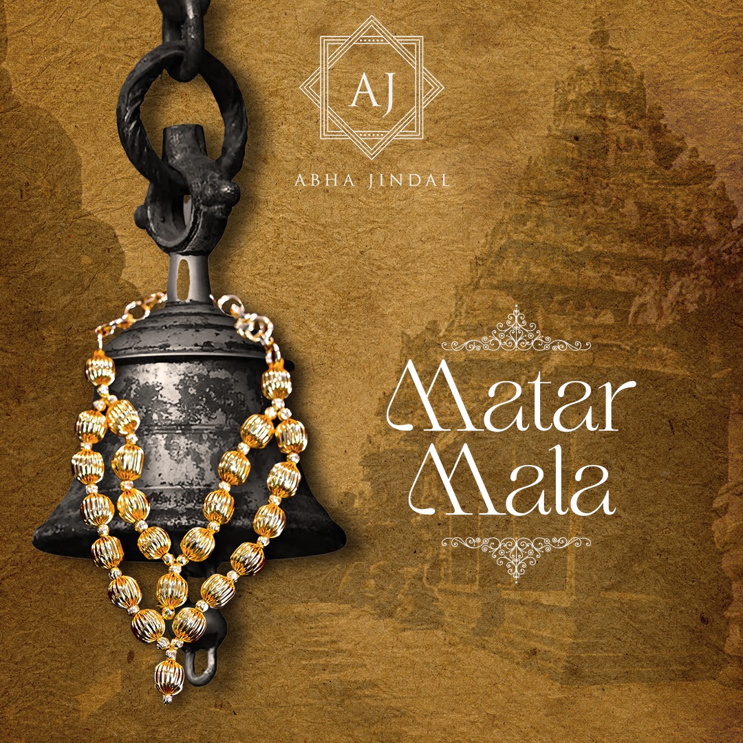 Long matar mala of ribbed gold-tone beads draped over a dark bell