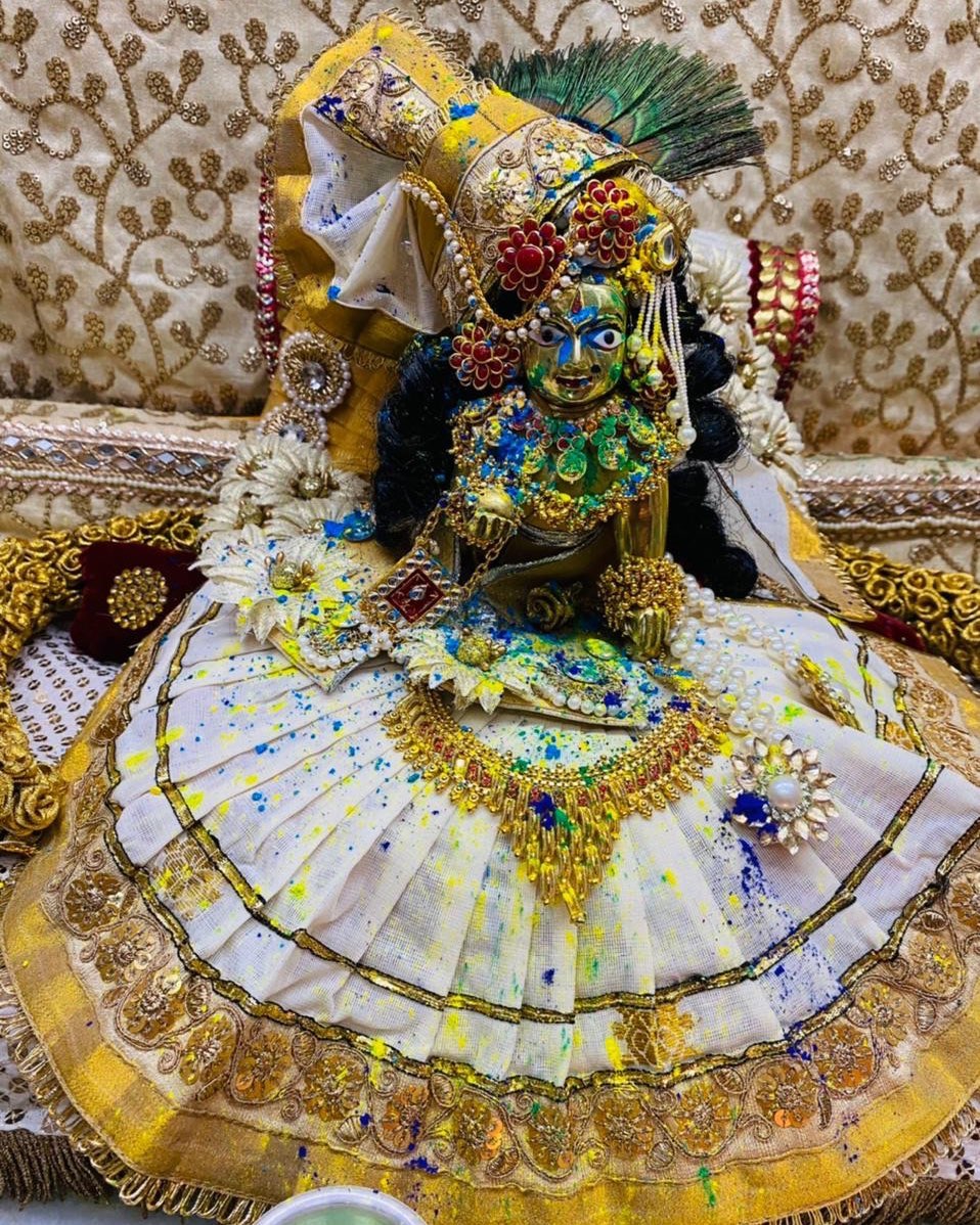 Laddu Gopal in white and yellow fan-style poshak with multicolour floral details