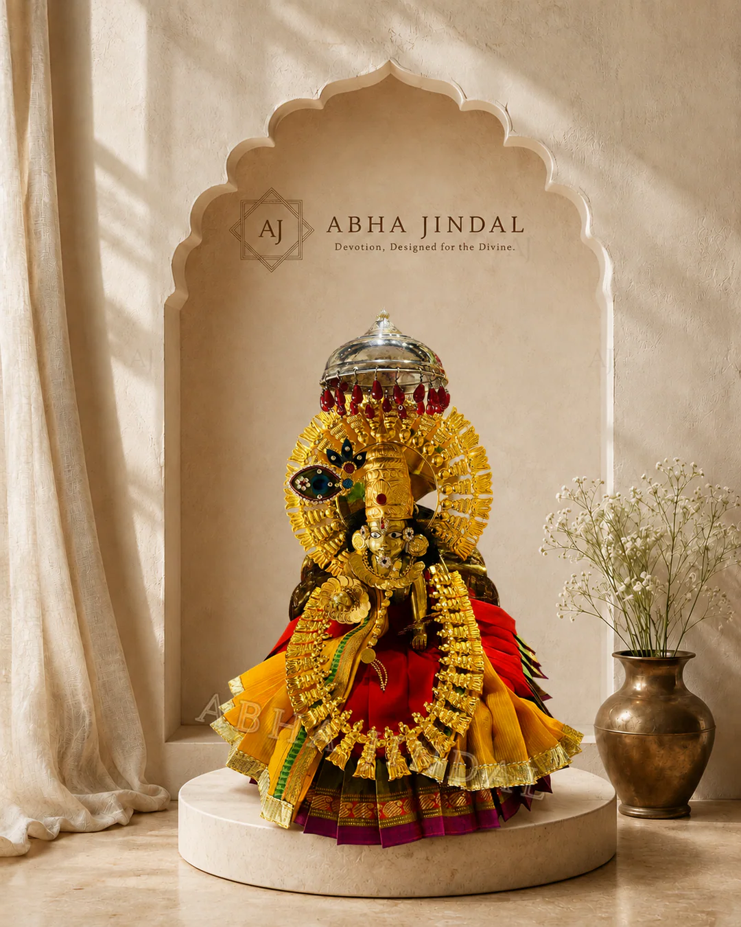 Laddu Gopal in red and yellow tiered pleats with green details and a circular headpiece