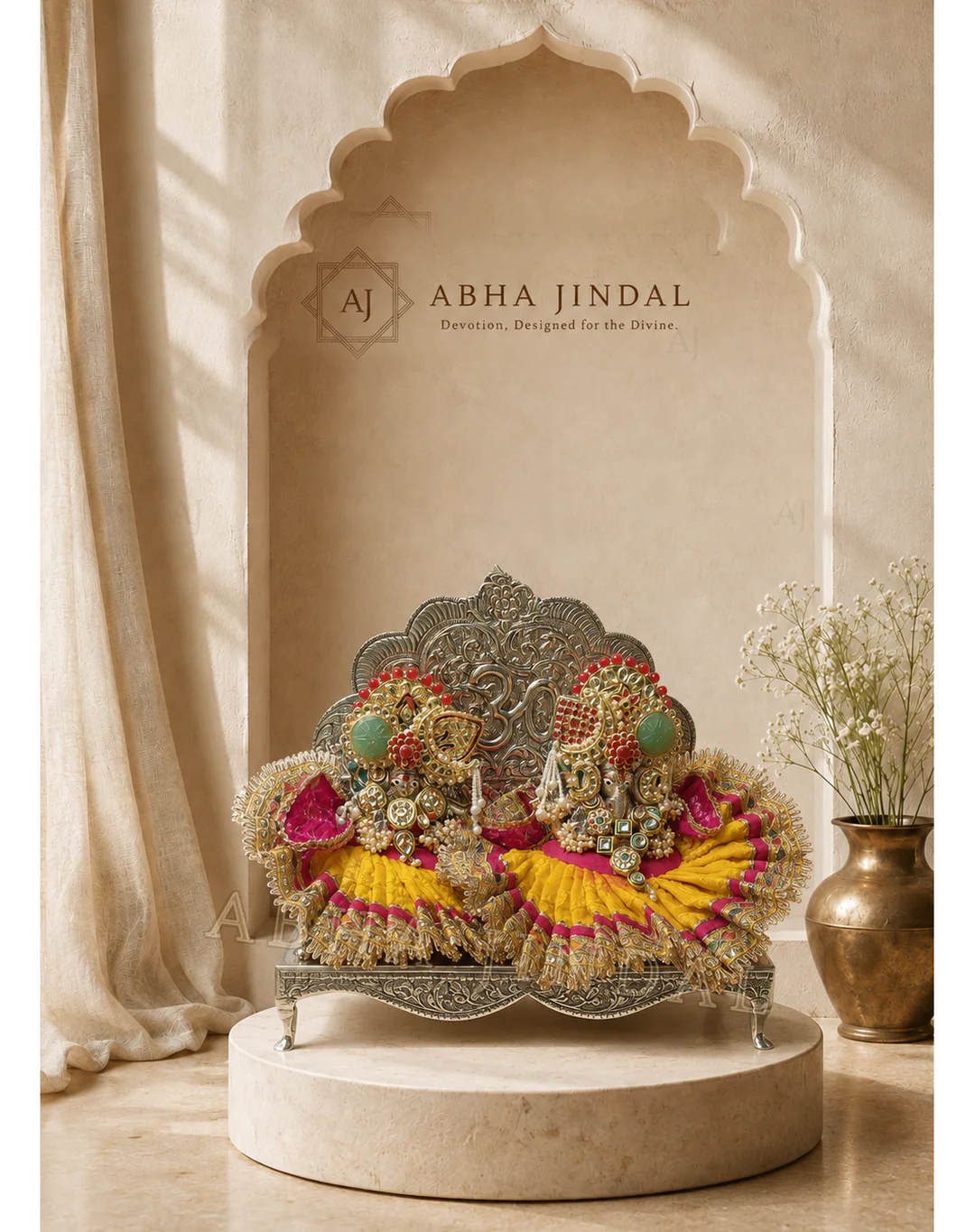 Ganesh Ji and Lakshmi Ji seated on an ornate silver-toned throne in yellow, pink and red shringar