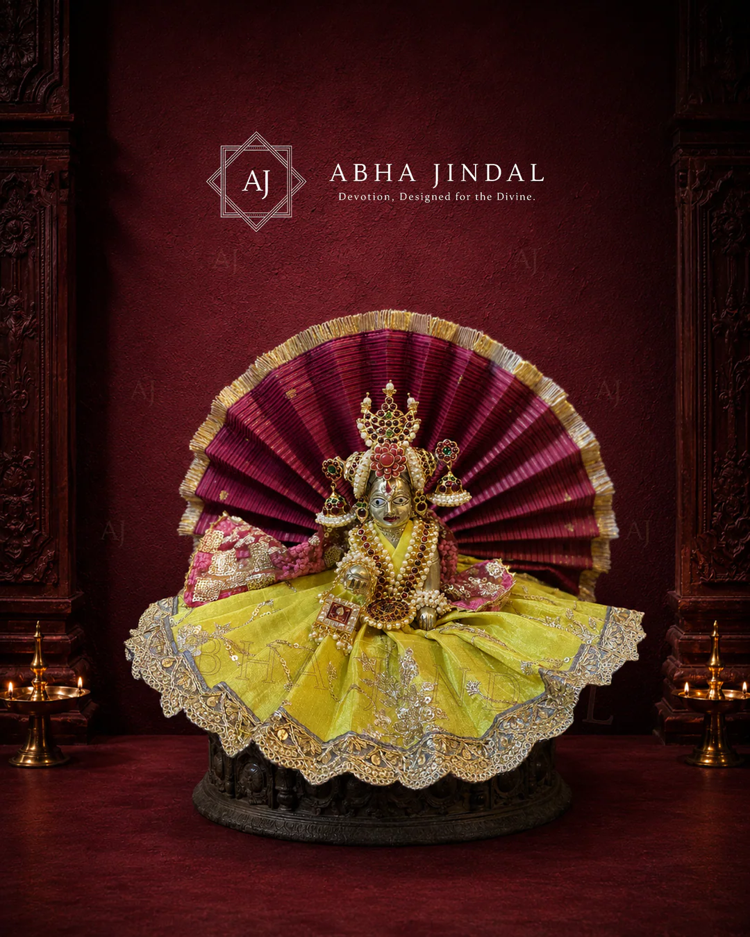 Laddu Gopal in the lime-yellow fan-style poshak against a deep wine-toned backdrop
