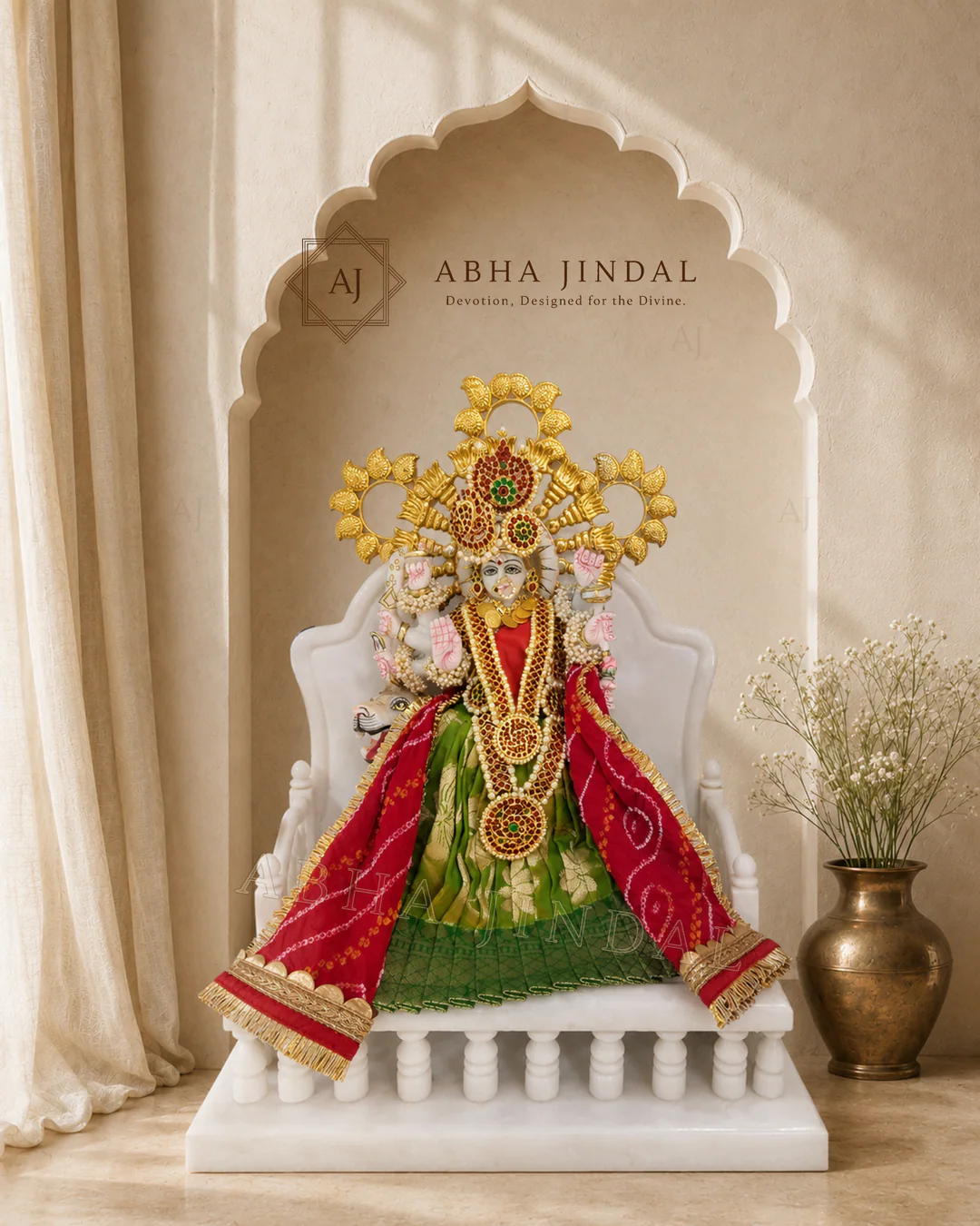 Mata Rani in green and magenta attire with a sculptural crown and white fan-style base