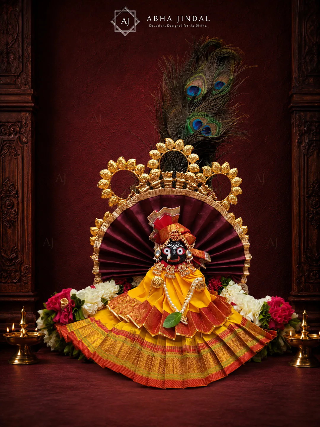 Front view of orange and yellow Shrinathji shringar with a maroon fan surround and peacock-feather crown