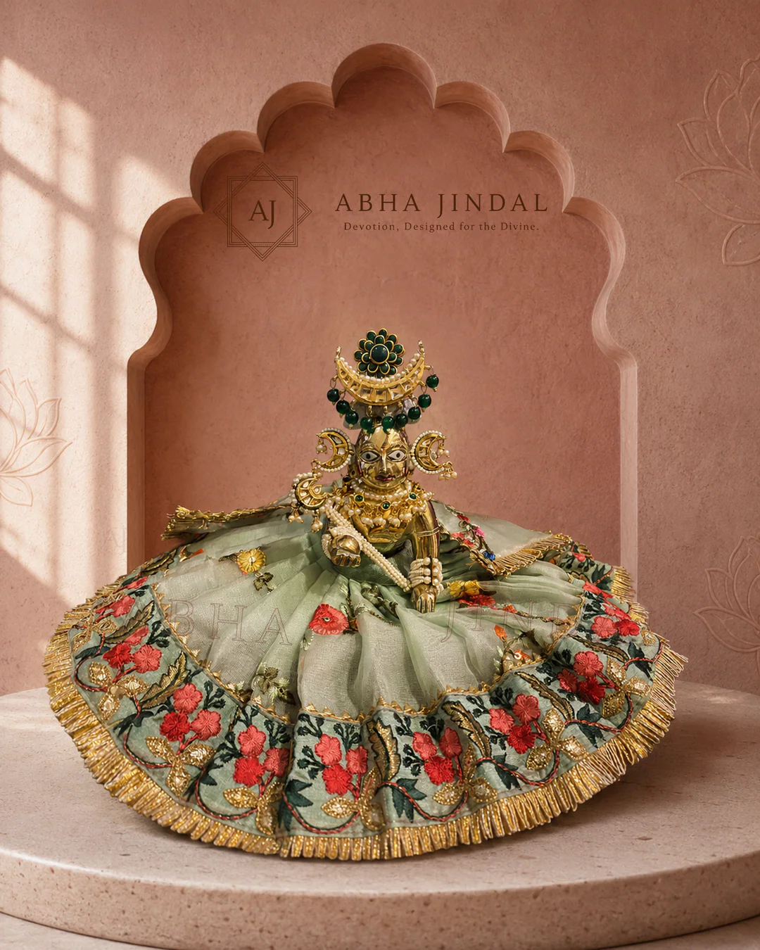 Laddu Gopal in sage-green floral attire with a wide circular skirt and dark green head adornment