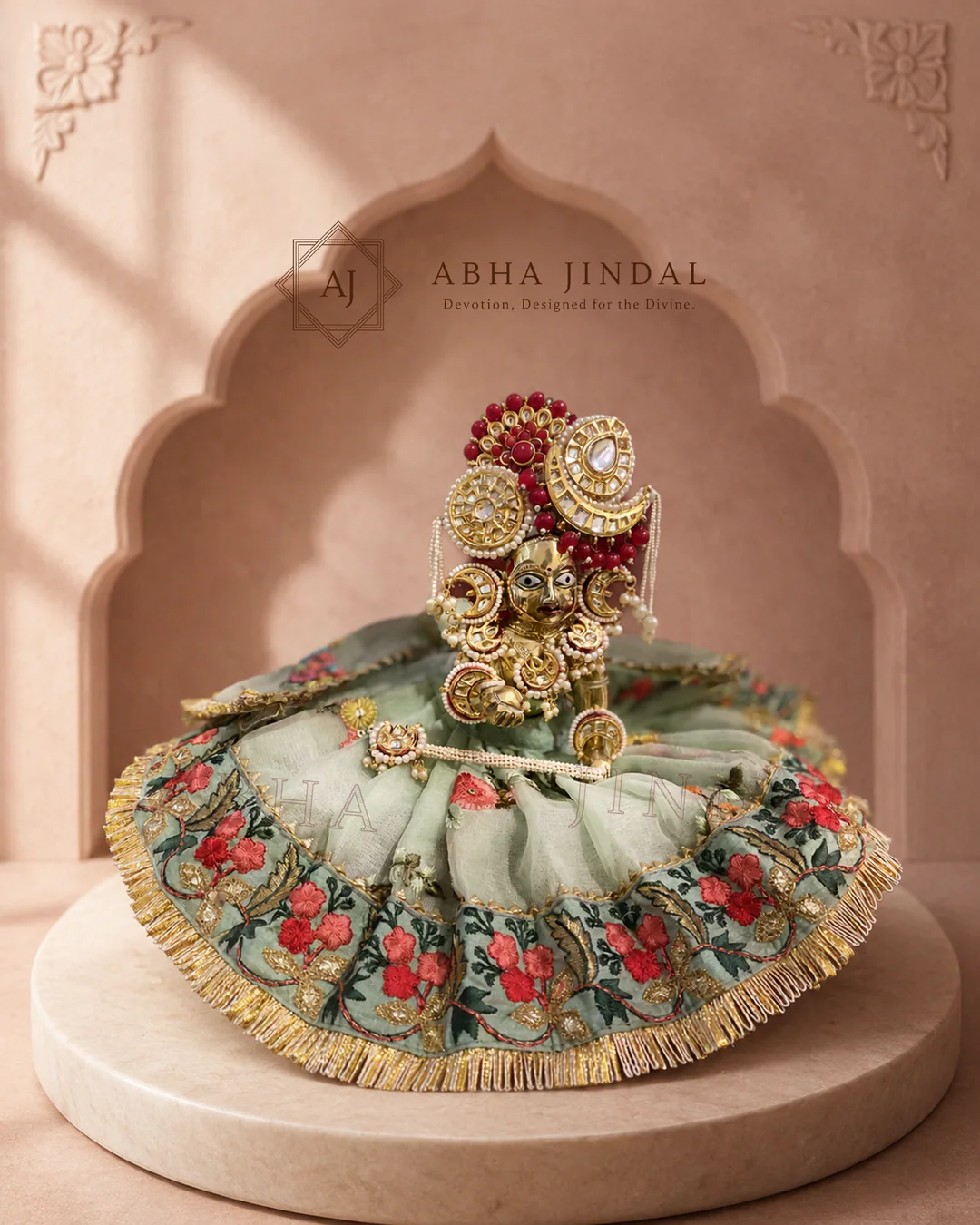 Laddu Gopal in sage-green floral attire with a broad circular skirt and round red-and-white crown