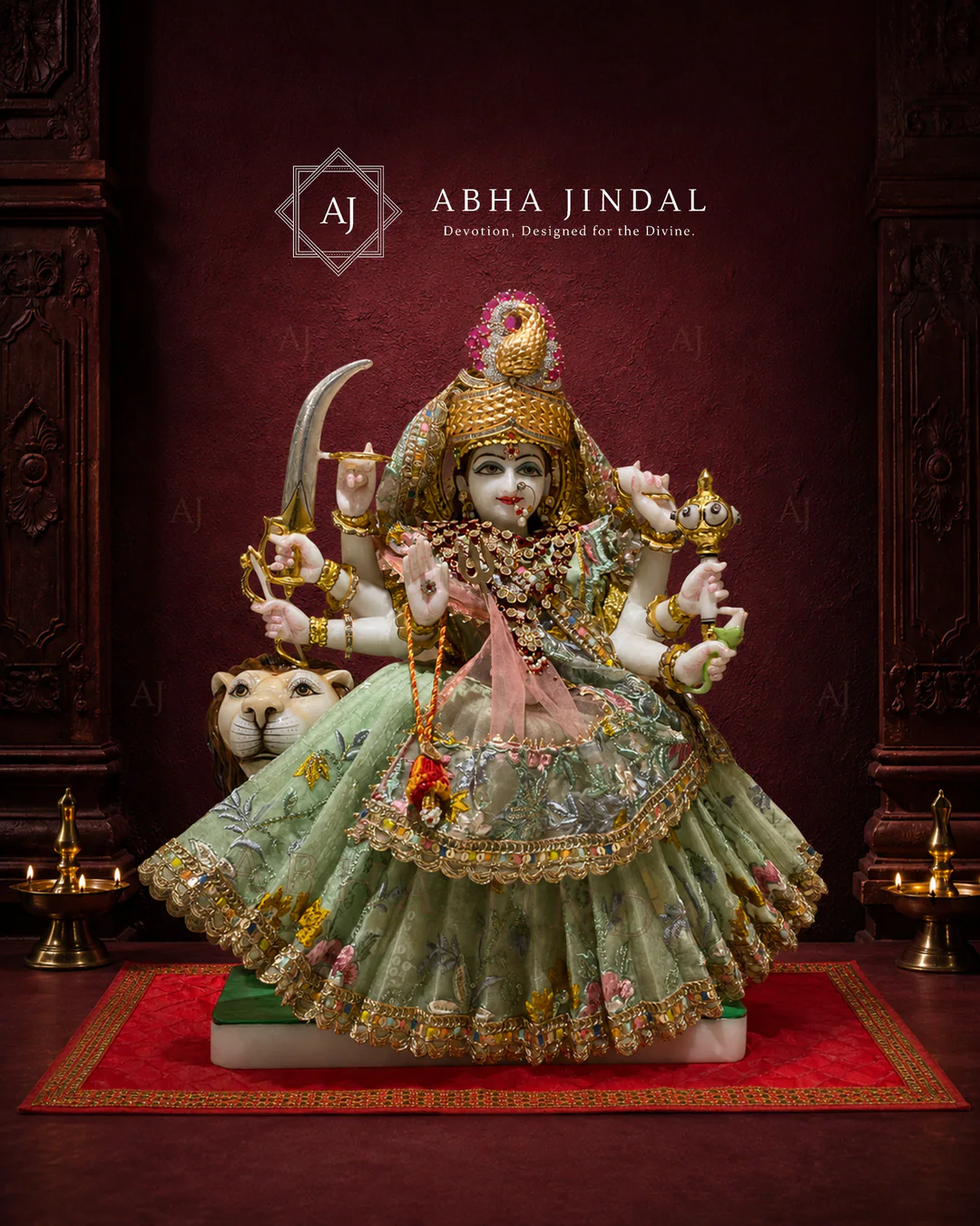 Mata Rani in sage green and pink attire with a lion figure, high crown and fan-shaped skirt