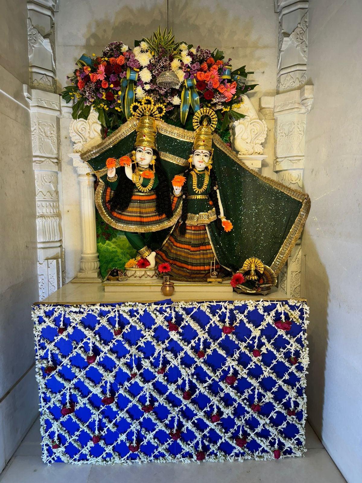 Two crowned shrine figures in coordinated black and orange attire within the Neemuch temple archive.