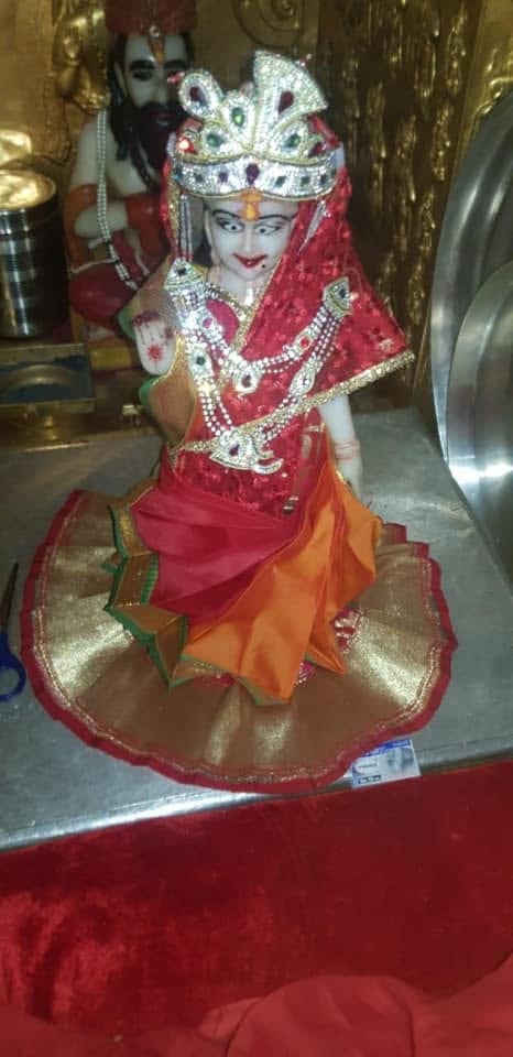 Small crowned subsidiary shrine figure in red and orange attire at Shri Salasar Balaji Mandir.